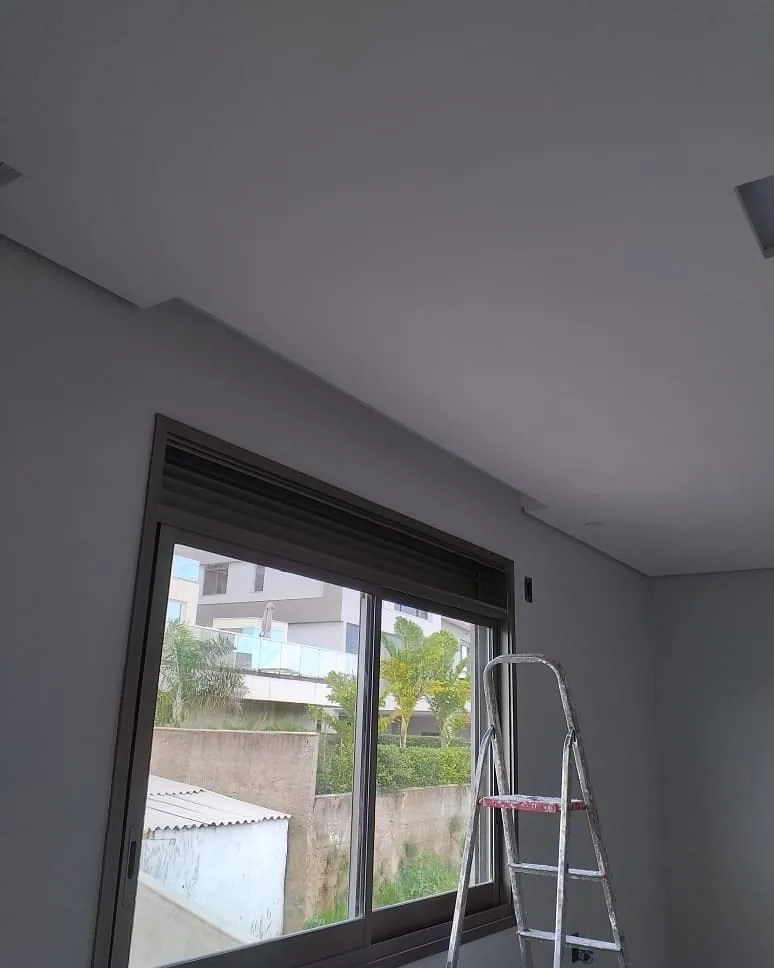 Casa na Península dos Pássaros, em Alphaville: quarto com janela larga e persiana, forro de gesso liso e uma escada de abrir no canto